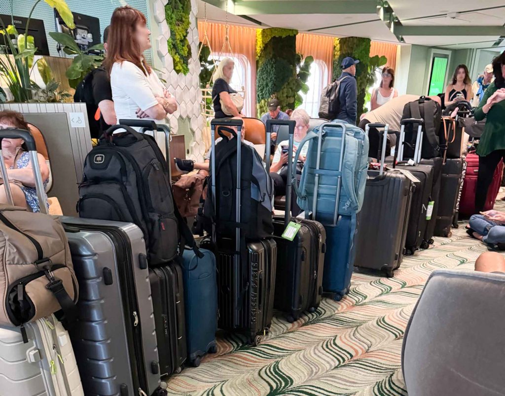 Cruise passengers line up for disembarkation, wishing they had learned cruise tips for first timers.