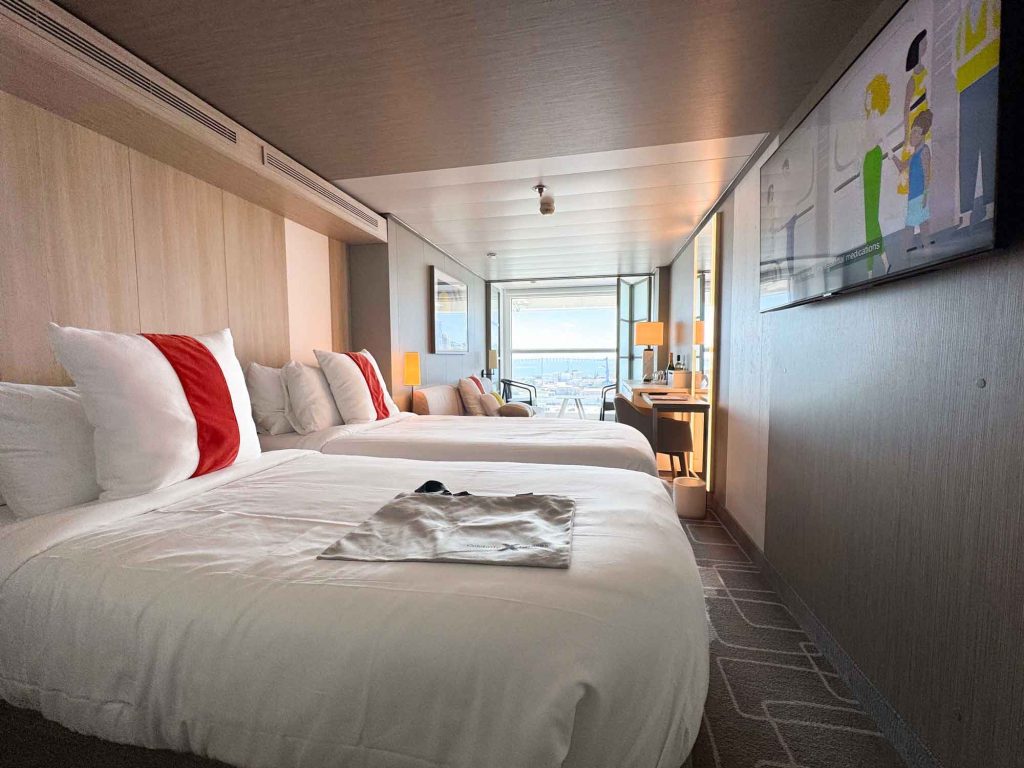 2 beds with white coverlets in front of open infinite veranda on a Celebrity Edge Class Ship Infinite Veranda stateroom.