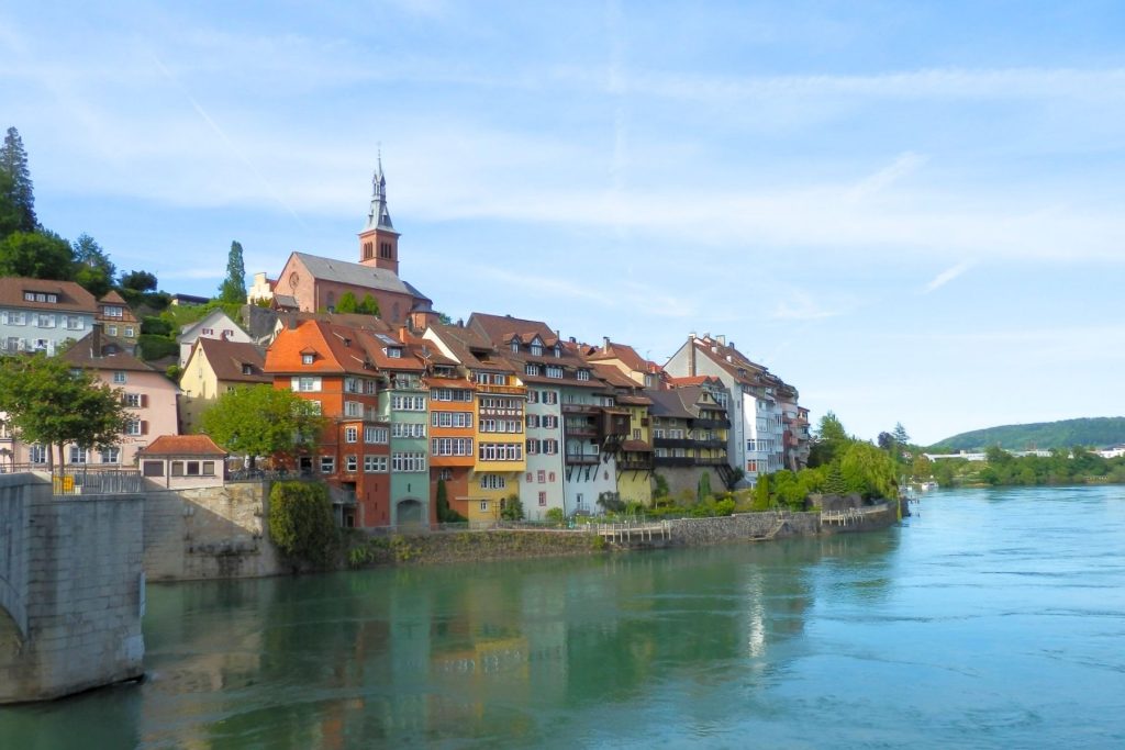 A colorful village of old-world buildings nestles along the banks of the Rhine River.