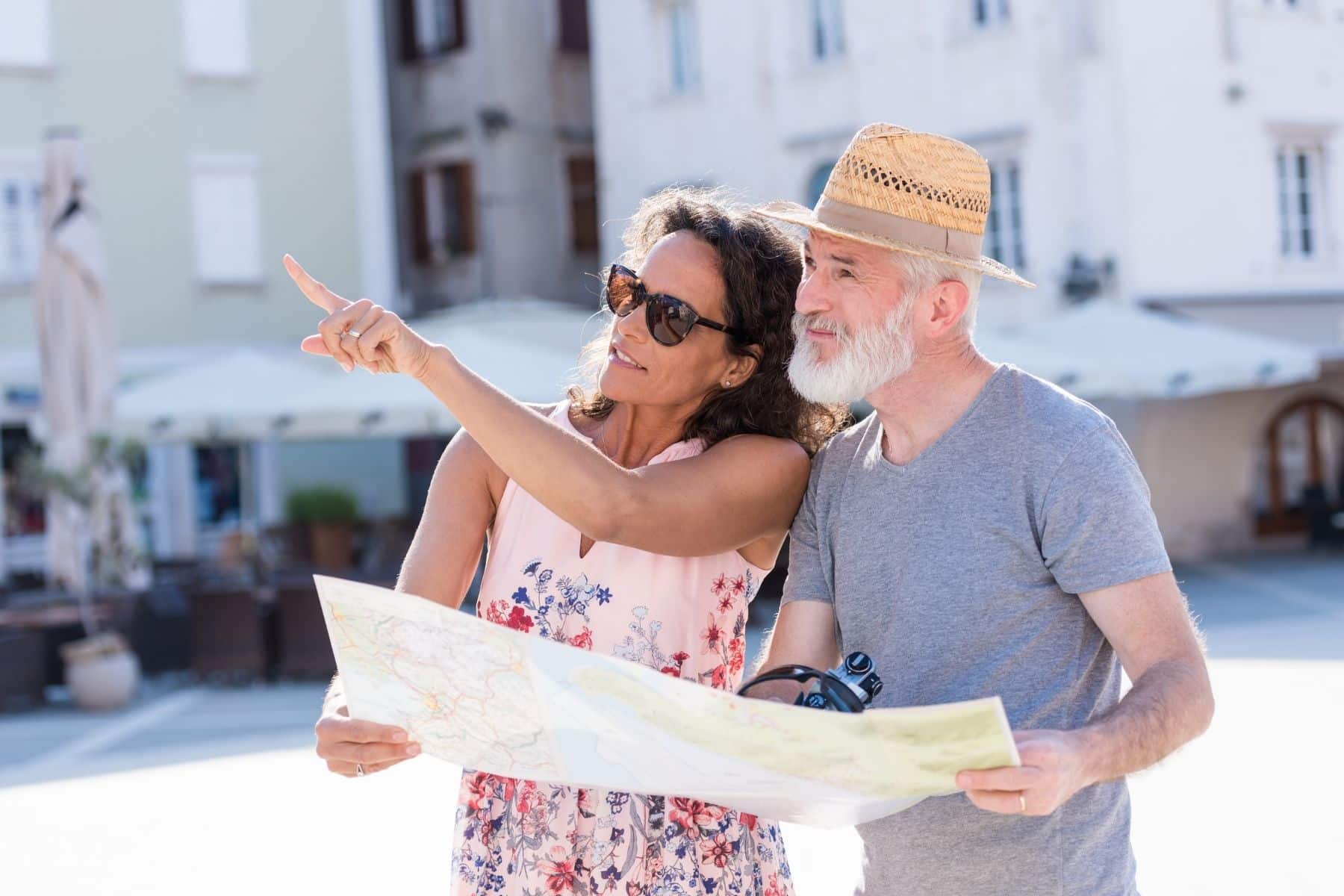 Two people of retirement age look at a map in a bucket list travel destination