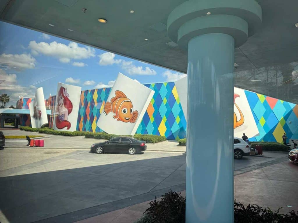 Disney characters grace the exterior of a multi-colored building at Disney's Art of Animation, where to stay at Disney World on a budget.